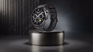 Black smartwatch with circular dial hovering above a metallic display plinth in a studio setting, showcasing its features.